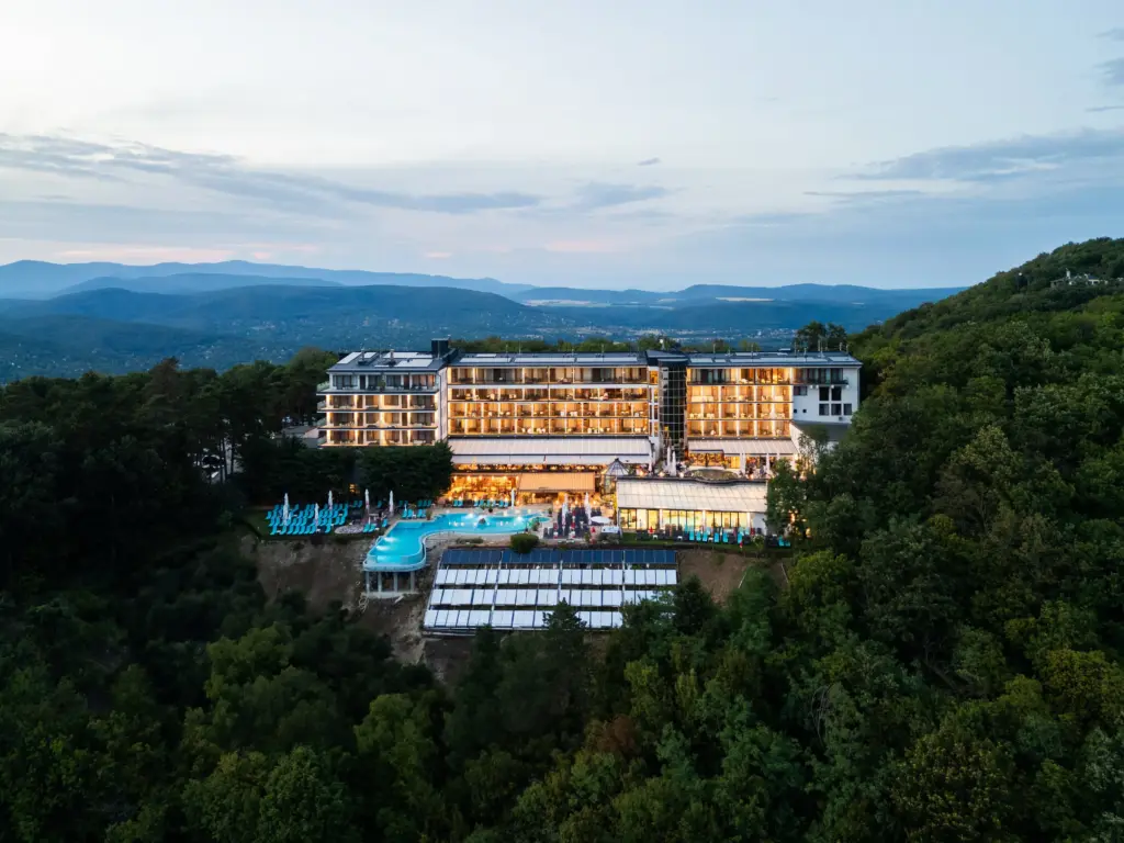 Esti légi felvétel a Silvanus Hotel Visegrádról, ahol a modern épület látható erdők között a Dunakanyar panorámájával és kültéri medencével